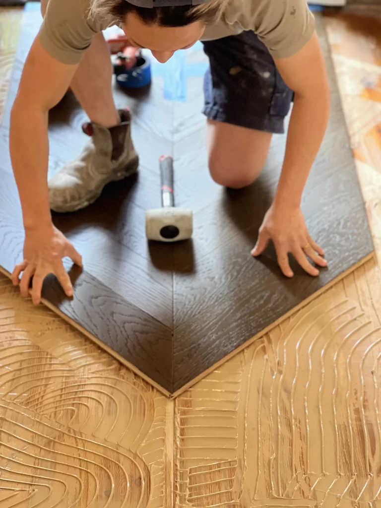 diamond floors' installation team installing dark tone engineered timbeer flooring in herringbone pattern using glued down method