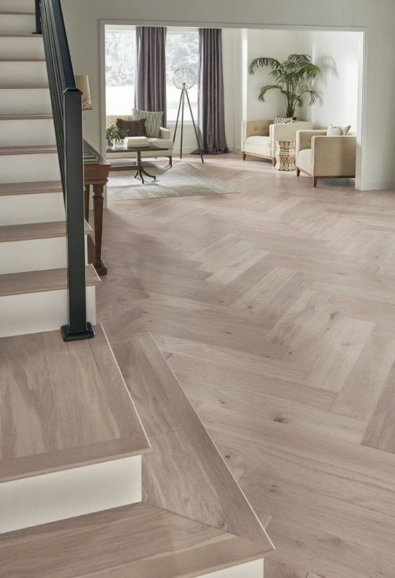 herringbone floor with a light beautiful tone and a staircase is visible